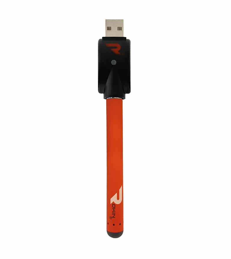 An orange vape pen with "ROKIN" printed vertically in white, connected to a black USB charger.