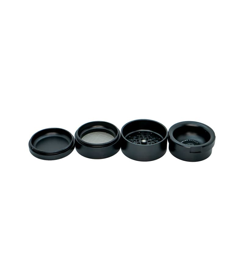 Four black, circular components of a grinder are laid out horizontally on a white background.