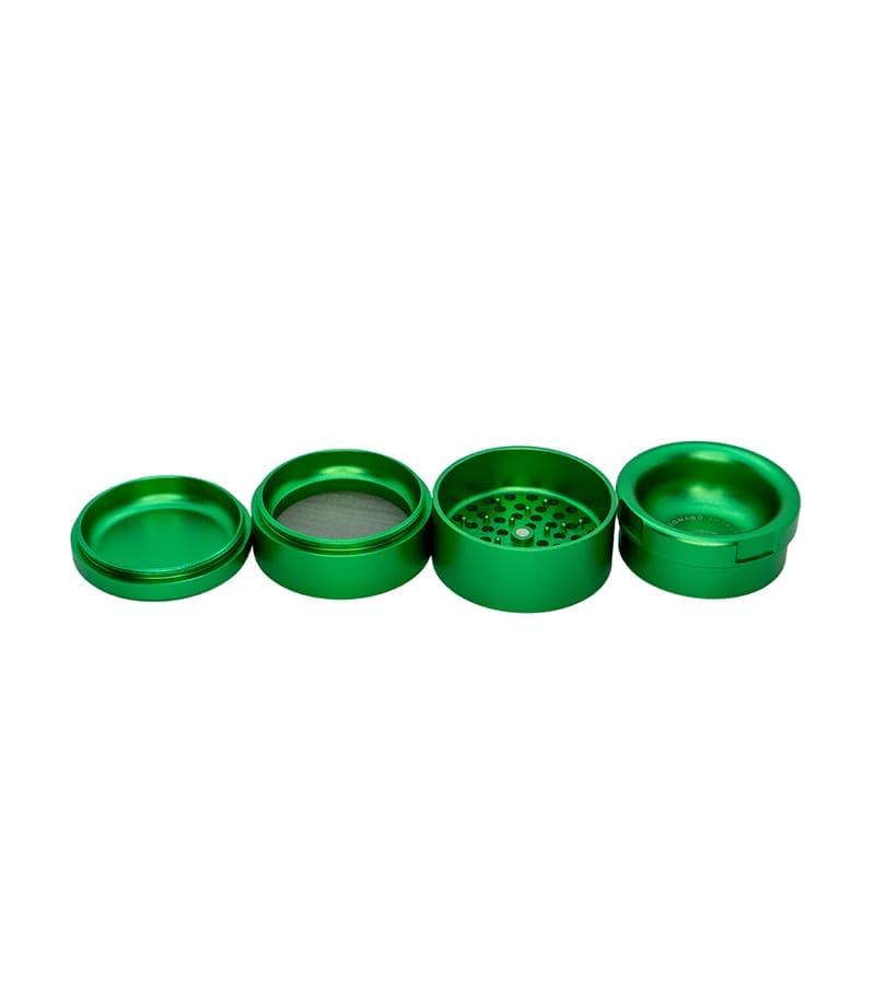 Four disassembled, round, metallic green grinder pieces are arranged in a line on a white background.