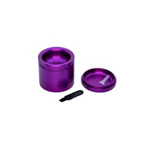 A purple metal grinder with a lid and a small black brush and white scraper on a white background.