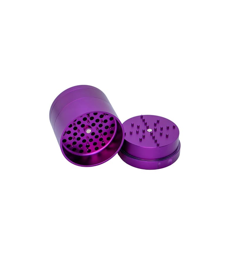 A purple metal grinder with its top removed, revealing sharp teeth and holes inside, on a white background.