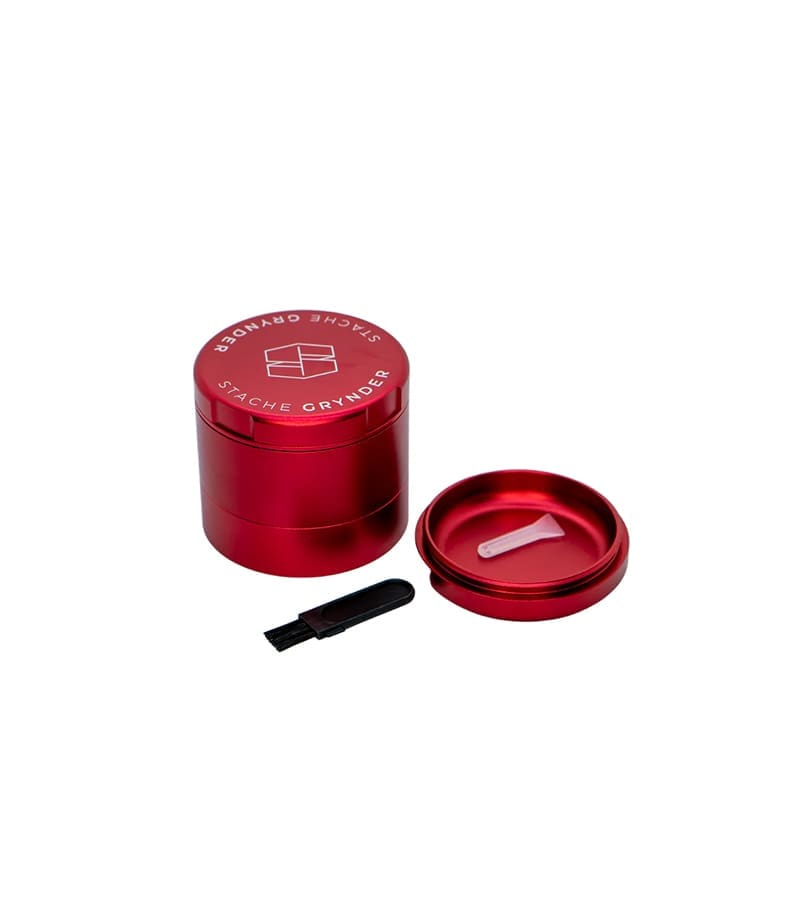 A red "STACHE GRYNDER" with a geometric logo, a small brush, and an open lid with a white scoop.