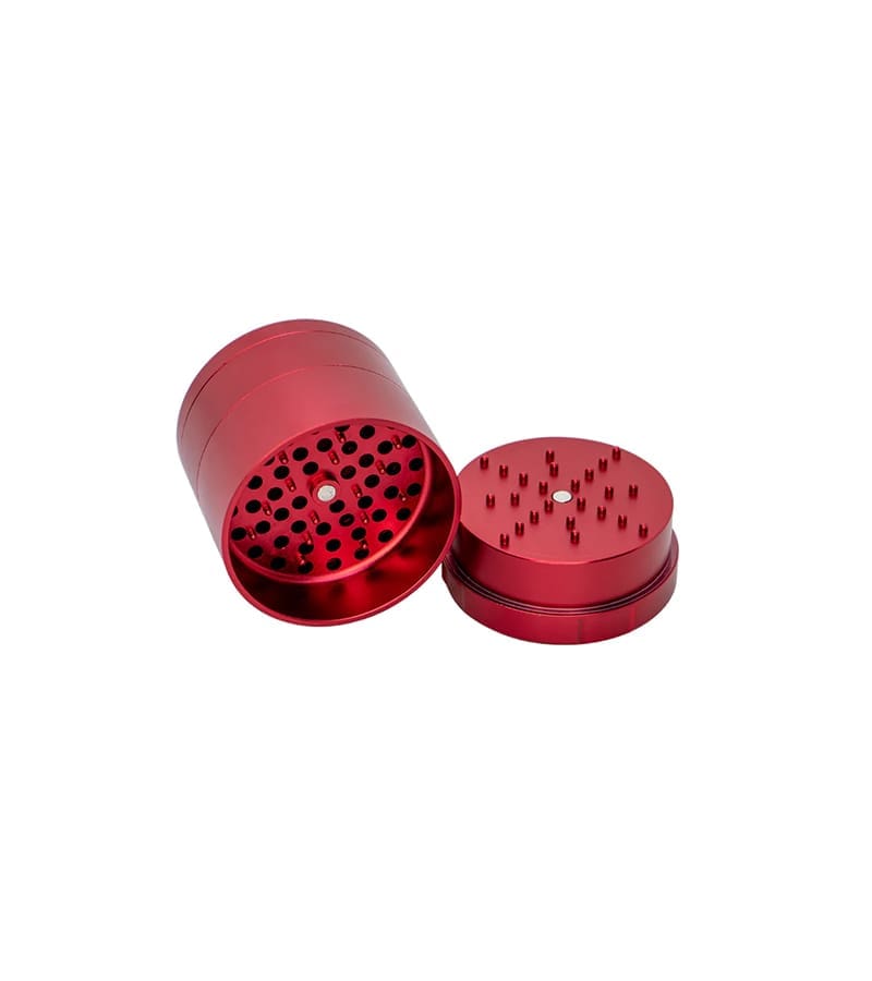 A red metal grinder with a textured top and a bottom piece with numerous small, sharp spikes.