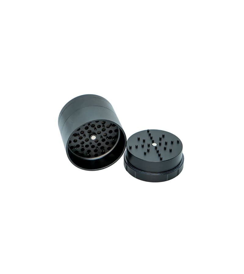 A black metal grinder is open, showing the top part with many small holes and the bottom with pegs.
