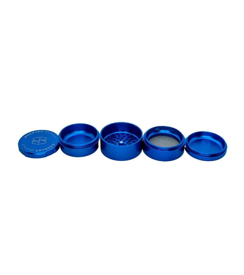 A four-piece blue metal herb grinder is disassembled, revealing "STACHE GRYNDER" on the lid.