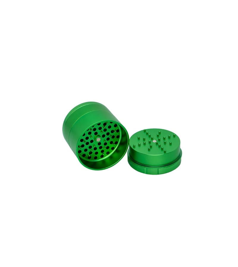 A bright green metal herb grinder is open, showing the top with grinding teeth and the bottom with holes.
