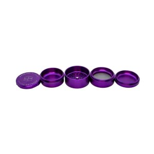 A disassembled purple metal grinder with "STACHE GRYNDER" embossed on the top lid, on a white background.