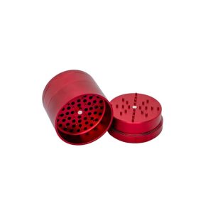 A shiny red metal grinder is open, showing a cylindrical base with many holes and a lid with grinding teeth.