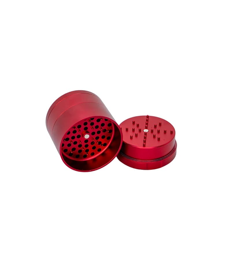 A shiny red metal grinder is open, showing a cylindrical base with many holes and a lid with grinding teeth.