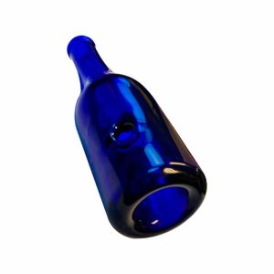 A dark blue glass bottle with a small circular indentation on its side lies diagonally against a white background.