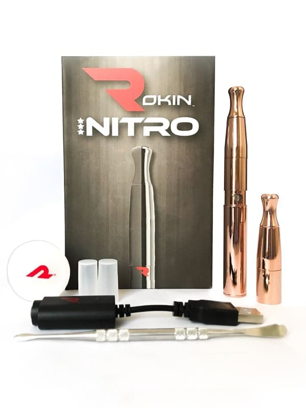 A Rokin Nitro vape kit, including a box, two rose gold vapes, a charger, and tools.