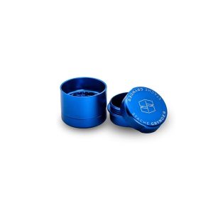 A shiny blue metal grinder with "STACHE GRYNDER" on the lid, on a white background.