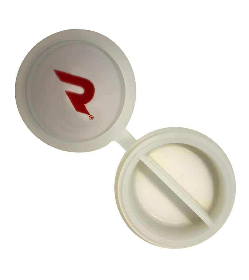 An open white round pill case with a red "R" logo on the lid and two compartments inside.